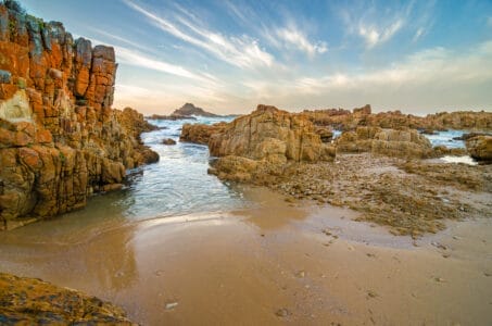 „Sonnenuntergang an den Knysna Heads, Felsen und Küste am Indischen Ozean, Garden Route, Südafrika.
