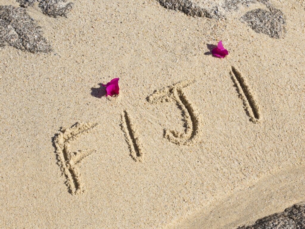 Strandsand mit Schriftzug und Blüten
